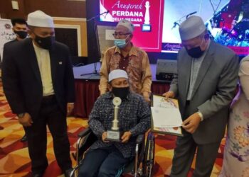 AHMAD Yakob (kanan) menyampaikan hadiah kepada penerima Anugerah Belia Negara Peringkat Negeri Kelantan, Roslan Ismail di Kota Bharu, Kelantan, hari ini. - FOTO/ROSALWANI CHE SOH