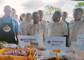 SAARANI Mohamad (tengah) melawat gerai jualan di pekarangan Dewan ADTECH sempena Program Hari Mesra bertemu Pelanggan di Taiping hari ini. - UTUSAN/WAT KAMAL ABAS