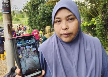 RASIDAH Nasir menunjukkan baki alatan mengaitnya seperti benang yang rosak susulan kejadian banjir yang melanda Kampung Seperi, Jelebu, baru-baru ini. - UTUSAN/NOR AINNA HAMZAH