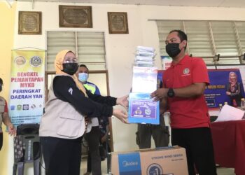 WASITAH Mohd. Yusof (kiri) menyampaikan sumbangan kepada wakil kakitangan Pejabat Majlis Belia Daerah Yan untuk diserahkan kepada mangsa kepala air di Yan, Kedah, hari ini. - UTUSAN/NUR ANATI JUHARI