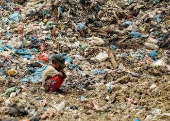 ANAK pemungut sampah duduk mencangkung di tapak pelupusan sampah di Alue Liem, Lhokseumawe.-AFP