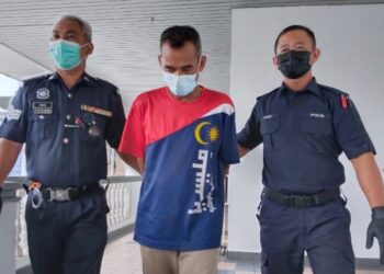 RIDZUWAN Sulaiman diiring keluar anggota polis selepas dihadapkan ke Mahkamah Sesyen, Ayer Keroh, Melaka atas pertuduhan amang seksual terhadap seorang remaja perempuan. - FOTO/MUHAMMAD SHAHIZAM TAZALI