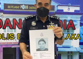 ABDUL Majid Mohd. Ali menunjukkan gambar suspek dikenali sebagai Analita yang diburu kerana dipercayai menjadi bidan dalam kegiatan menjual bayi sekitar Melaka dan Negeri Sembilan. - FOTO/DIYANATUL ATIQAH ZAKARYA