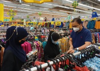 MOHD. Rafiq Naizamohideen (kanan) membantu memilih baju Melayu pada program beli-belah raya untuk anak yatim dan fakir miskin anjuran Bersatu Bahagian Tangga Batu di Pasaraya Mydin, Ayer Keroh, Melaka. - FOTO/MUHAMMAD SHAHIZAM TAZALI