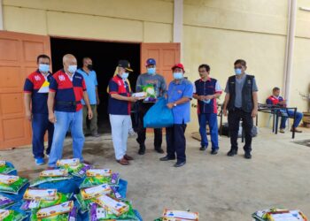 ISMAIL Abd. Muttalib (tiga dari kiri) menyampaikan sumbangan barangan keperluan untuk penduduk yang dikuarantin kepada Ahmad Zubir Abdul Rahim (tiga dari kanan) di Maran, Pahang. - UTUSAN/SALEHUDIN MAT RASAD