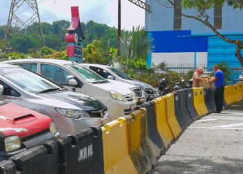 SEORANG wanita menghantar kotak barangan kepada pelanggannya di sempadan antara Bandar Seri Putra, Selangor dan Nilai 3, Nilai dekat Seremban selepas penutupan Jalan Bangi-Nilai ekoran pelaksanaan (PKP di enam daerah di Selangor.- UTUSAN/MUHAMMAD IZZAT TERMIZIE