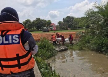 ANGGOTA bomba mengangkat mayat lelaki yang ditemukan lemas setelah terjatuh ke dalam sungai Hutan Melintang, Teluk Intan, Perak, hari ini. - FOTO/IHSAN JBPM