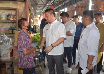 NGA Kor Ming (kanan) beramah mesra bersama peniaga ketika melawat Pasar Besar Teluk Intan hari ini. - UTUSAN/ZULFACHRI ZULKIFLI