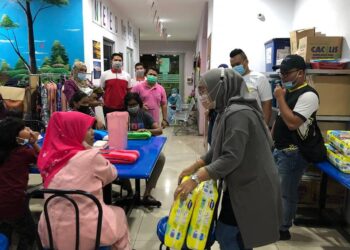 NORHASLINDA Zakaria (kanan) menyantuni gelandangan di pusat kebajikan Anjung Singgah YKN Perak di Ipoh semalam.