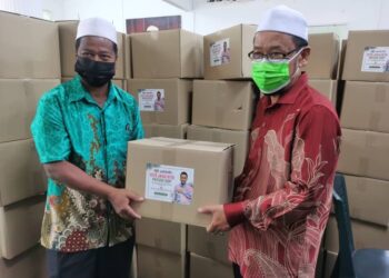 CHE ABDULLAH Mat Nawi  (kiri) mengagihkan kotak makanan kepada penghulu untuk disampaikan kepada golongan memerlukan di Parlimen Tumpat, Kelantan, hari ini. - UTUSAN/ROSALWANI CHE SOH