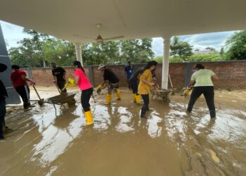 Nina Sabrina Ismail Sabri (baju kuning) bersama beberapa sukarelawan membersihkan sumah salah seorang mangsa banjir di di Kampung Dusun Tua, Hulu Langat, Selangor.