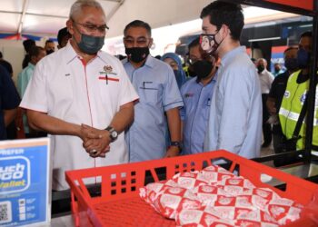 NOH Omar (kiri) melawat gerai peserta Program Usahawan Dan Koperasi Keluarga Malaysia di Sungai Besar, Sabak Bernam, Selangor hari ini. - UTUSAN / ABDUL RAZAK IDRIS