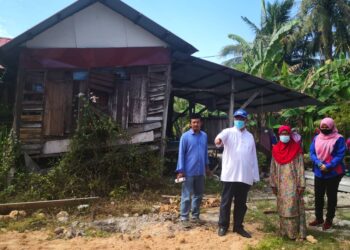 NOH Omar (dua kiri) bersama Noryah Mohamed (dua kanan) di hadapan rumah usang itu di Jalan Pantai Rasa Sayang, Sungai Burong,Tanjong Karang, Selangor, hari ini. -UTUSAN/ISKANDAR SHAH MOHAMED