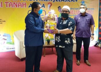 MOHD. Khidir Majid (kiri) menyampaikan cenderahati kepada salah seorang pembayar cukai terawal pada Majlis Pelancaran Kempen Jom Bayar Cukai Tanah 2022 Daerah Seremban hari ini.