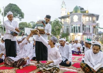 PELATIH Madrasah Darul Solihin Al-Qadiri berkumpul membaca ayat suci Al-Quran dan menunaikan solat Maghrib berjemaah sempena sambutan Nuzul Quran di Jalan Kebun, Shah Alam, Selangor. - UTUSAN/ZULFADHLI ZAKI