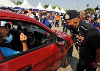 KAMARUL Zaman Mamat menyampaikan cenderahati kepada salah seorang pemandu kenderaan pada Majlis Pelancaran Op Selamat Kontinjen Johor Sempena Tahun Baharu Cina di Plaza Tol Kempas, Johor Bahru. -UTUSAN /RAJA JAAFAR ALI