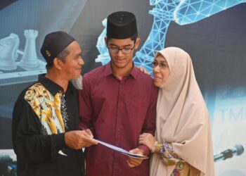 TENGKU Abdul Aziz Tengku Md. Fauzi (tengah) menerima ucapan tahniah daripada bapa, Tengku Md. Fauzi Tengku Mahmud dan ibu, Wan Hindon Wan Abdullah selepas menerima Anugerah Pelajar Cemerlang SPM 2021 di Kuala Terengganu, semalam. - UTUSAN/PUQTRA HAIRRY ROSLI