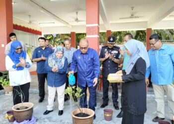 MOHD. Zolkafly Harun (tengah) menyiram pokok sebagai gimik perasmian Karnival dan Pameran STEM di SK Lintang, Sungai Siput hari ini. - UTUSAN/ASLIZA MUSA