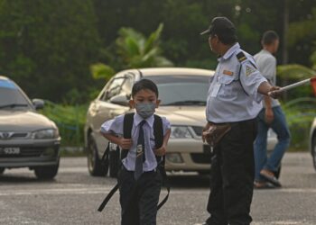 SEORANG murid memakai pelitup muka ketika hadir pada hari pertama pembukaan semula sesi persekolahan di Sekolah Kebangsaan Padang Mengkuang, Marang, Terengganu, semalam. - UTUSAN/PUQTRA HAIRRY ROSLI