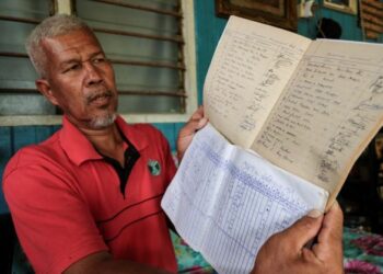 MOHD. Ridzwan Abdul Mubin menunjukkan buku rekod jumlah pemandu bot pada tahun 90-an yang semakin berkurangan bermula pertengahan 2010 di Kampung Belimbing, Pekan, Pahang. - UTUSAN/MUHAMAD IQBAL ROSLI