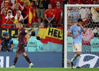 Penjaga gol Maghribi, Yassine Bounou (kiri) tersenyum ketika melepasi pemain tengah Sepanyol, Sergio Busquets yang gagal menyempurnakan sepakan penalti, semalam. – AFP