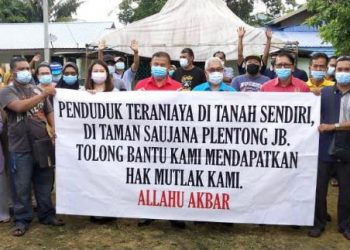 HASSAN Karim (depan, empat dari kanan) bersama penduduk setempat mohon kerajaan menyelesaikan masalah tanah penduduk kampung Taman Sri Saujana, Plentong, Pasir Gudang, Johor. - FOTO/BAAZLAN IBRAHIM