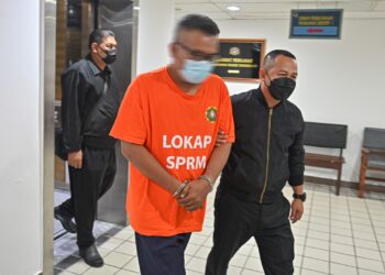 SEORANG pengurus di sebuah jabatan Kerajaan Persekutuan yang ditahan bagi membantu siasatan kes penyalahgunaan kuasa dibawa di Mahkamah Majistret Kuala Terengganu, hari ini. - UTUSAN/PUQTRA HAIRRY ROSLI