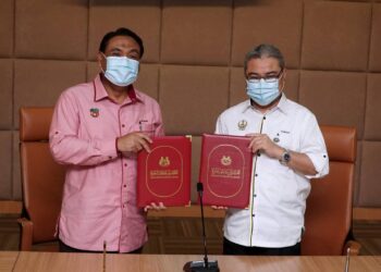 RUMAIZI Baharin (kanan) bertukar dokumen perjanjian  dengan Yahanis Yahya bagi pembangunan projek pertanian bandar  di kaki gunung Gunung Matsoorat di Ipoh har ini. - UTUSAN/ZULFACHRI ZULKIFLI