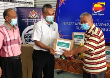 KETUA Pegawai Operasi Petronas Pantai Timur, Azeman Said (tengah) menyampaikan sumbangan kepada seorang penerima di Dungun sempena program Sentuhan Kasih Tahun Baharu Cina 2021 di Kuala Terengganu hari ini.