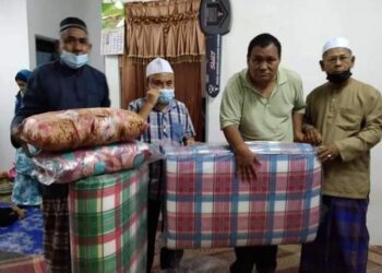 ROSLI Mat Yassin (dua dari kanan) menerima sumbangan peralatan tidur daripada Mustapa Long (dua dari kiri) di Kampung Balik Gua, Lipis, Pahang.