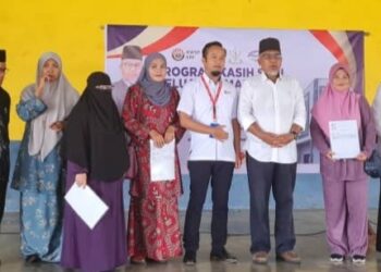 AHMAD Nazlan Idris (tiga dari kanan) bersama penerima bantuan Program Kasih Suri Keluarga Malaysia (I-SURI) di Perumahan Kos Rendah 410, Jerantut, Pahang. - FOTO/HARIS FADILAH AHMAD