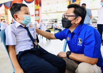 MOHAMAD Alamin (kanan) menyantuni seorang murid ketika lawatan kerja ke Sekolah Kebangsaan (SK) Durian Tawar di Bera, Pahang. - FOTO/SALEHUDIN MAT RASAD