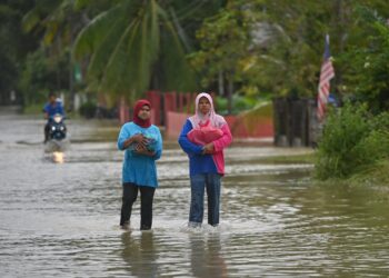 SEBAHAGIAN penduduk yang dipindahkan di PPS SK Kampung Nyior mula pulang ke rumah mereka di Kampung Pinang Merah, Paka, Dungun, hari ini. - UTUSAN/PUQTRA HAIRRY