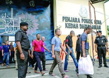 SEBAHAGIAN daripada 14 banduan atau ‘orang bebas berlesen’ 
diiringi keluar dari Penjara Pokok Sena, Kedah semalam. – UTUSAN/
SHAHIR NOORDIN