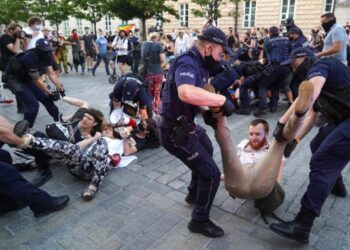 Polis menahan aktivis LGBT yang menghalang jalan kereta polis yang memindahkan aktivis gay, Margo 
di Warsaw, Poland, Ogos lalu. – AFP