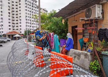 Salmah Omar 64 (kanan), bersama anaknya Izzah Athirah Hadzet 5, berbual di luar rumahnya yang terlibat dalam kawasan Perintah Kawalan Pergerakan Diperketatkan (PKPD), Taman Ikan Emas, Kuala Lumpur hari ini. -UTUSAN/SHIDDIEQIIN ZON