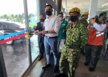 MUHAMAD Akmal Saleh mengunci pintu hadapan MITC sebagai simbolik penutupan PKRC di Ayer Keroh, Melaka. - UTUSAN/AMRAN MULUP