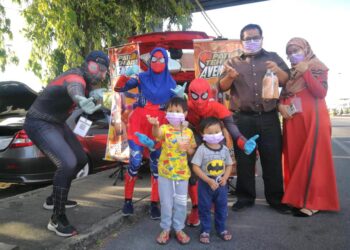 PELANGGAN bergambar dengan ‘adiwira’ termasuk Spidergirl yang menjual jenama Pati Teh Ais Avenger di Jalan Raja Syed Alwi, Kangar, Perlis.– UTUSAN/NAZLINA NADZARI