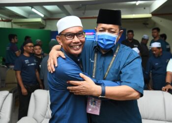 MOHD. Shukri Ramli (kiri) memeluk Shahidan Kassim yang meraikan kejayaan PN menyapu 14 daripada 15 kerusi DUN Perlis di Kompleks Pas, Kangar, Perlis. - UTUSAN/IZLIZAN OTHMAN