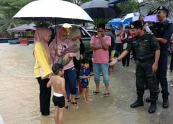 ROHAIMI Md. Isa (dua, kanan) beramah mesra dengan mangsa banjir di Kampung Kua, Hulu Terengganu, hari ini. - UTUSAN/NOOR HAYATI MAMAT