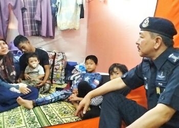 MUHAMAD Zaki Harun (kanan) beramah mesra dengan mangsa banjir di PPS SK Gual To'Deh Rantau Panjang, Kelantan. UTUSAN/ROHANA ISMAIL