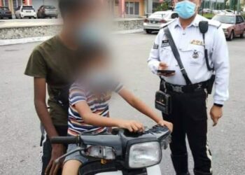 SEORANG remaja yang menunggang motosikal tanpa memakai topi keledar disaman polis dalam operasi di Bentong, Pahang semalam.