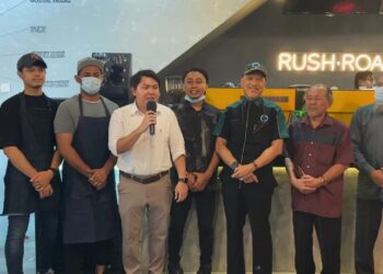 NADZIM Johan (tiga dari kanan) bersama barisan pekerja Rush Roastery X Doyan Ayam Malaysia di Mutiara Damansara, Petaling Jaya, hari ini.