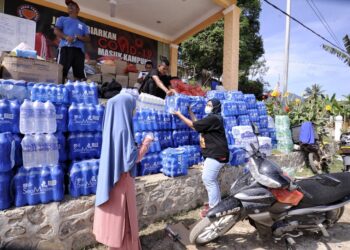 SUKARELAWAN dan penduduk membantu menyusun barangan bantuan kepada mangsa banjir yang disumbangkan pelbagai pihak di Kampung Chennah, Jelebu hari ini.-UTUSAN/MOHD. SHAHJEHAN MAAMIN