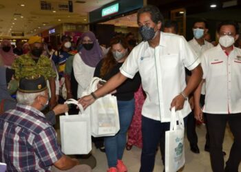 KHAIRY Jamaluddin mengedarkan beg risalah kepada pengunjung pada pelancaran Jelajah Agenda Nasional Malaysia Sihat peringkat negeri Perak di Meru Raya, Ipoh hari ini. - FOTO/ZULFACHRI ZULKIFLI