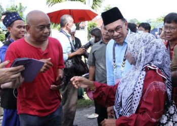 ANWAR Ibrahim beramah mesra dengan pengundi semasa meninjau pusat mengundi di Sekolah Kebangsaan Manjoi 1, Ipoh, hari ini. - FOTO/MUHAMAD NAZREEN SYAH MUSTHAFA