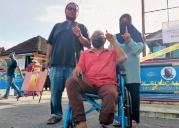 MUSHAR Nasipin (tengah) bersama isteri, Zainab Che Lop (kanan) dan anak mereka, Khairul Nizam selepas mengundi di SK Sungai Bayor, Rantau Panjang, Selama hari ini. - FOTO/ASLIZA MUSA