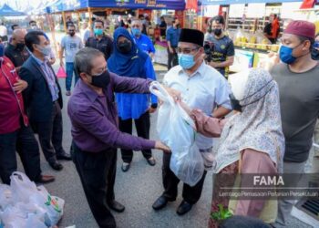 MOHAMAD Mustahapa Awang menyantuni pelanggan selepas melancarkan Program Jualan My Rakyat di ibu pejabat FAMA kelmarin. – FOTO/IHSAN FAMA