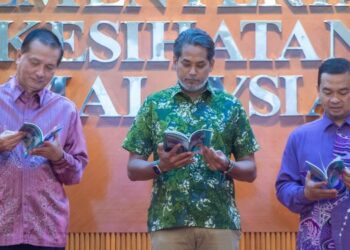 KHAIRY Jamaluddin melihat buku garis panduan EVALI pada Majlis Pelancaran Panduan Amalan Klinikal Pengurusan EVALI di Putrajaya. - FOTO/FAISOL MUSTAFA