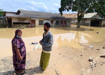 KHOTIJAH Hadrawi sedih melihat rumah sewanya dinaiki air di Kampung Sri Tanjung, Dengkil, Selangor. - FOTO/SITI A’ISYAH SUKAIMI